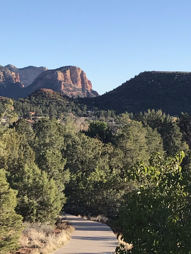 Walking path winding through a Sedona neighborhood toward red rock views